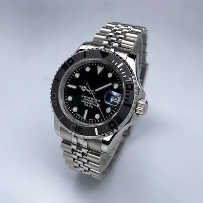 40 mm átmérőjű, YM Design kétirányban forgó keret, zafírüveg, világító számlap, NH35 szerkezethez, Jubile szíjjal ellátott luxus férfi karóra